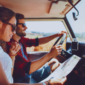 A couple in the car, passenger studying a road map