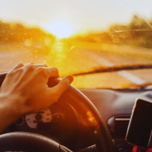View from behind the steering wheel, sun glinting off the windshield