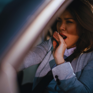 Woman yawning behind the wheel