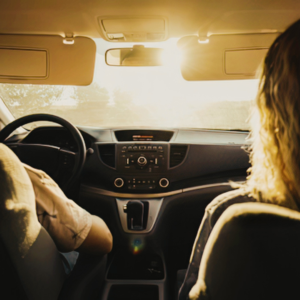 Couple in vehicle with sun glare against windshield
